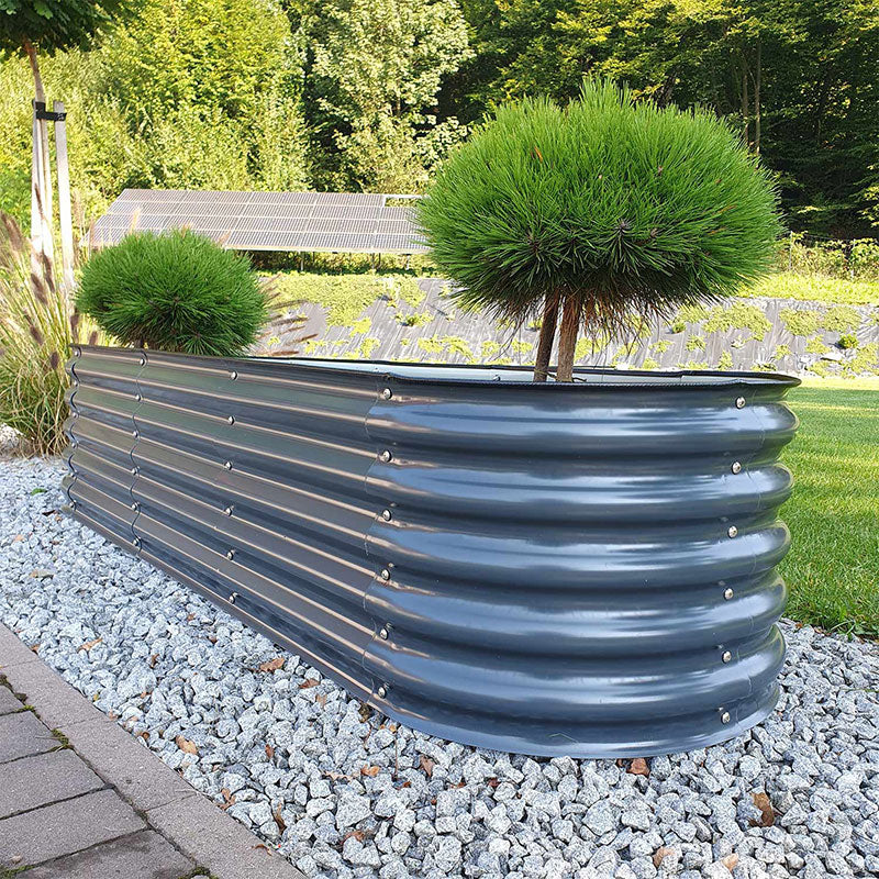 Metall Hochbeet auf einer Zierkiesfläche, umgeben von einer Gartenlandschaft. Es dient als stilvolle Begrenzung und zur Strukturierung des Gartens.